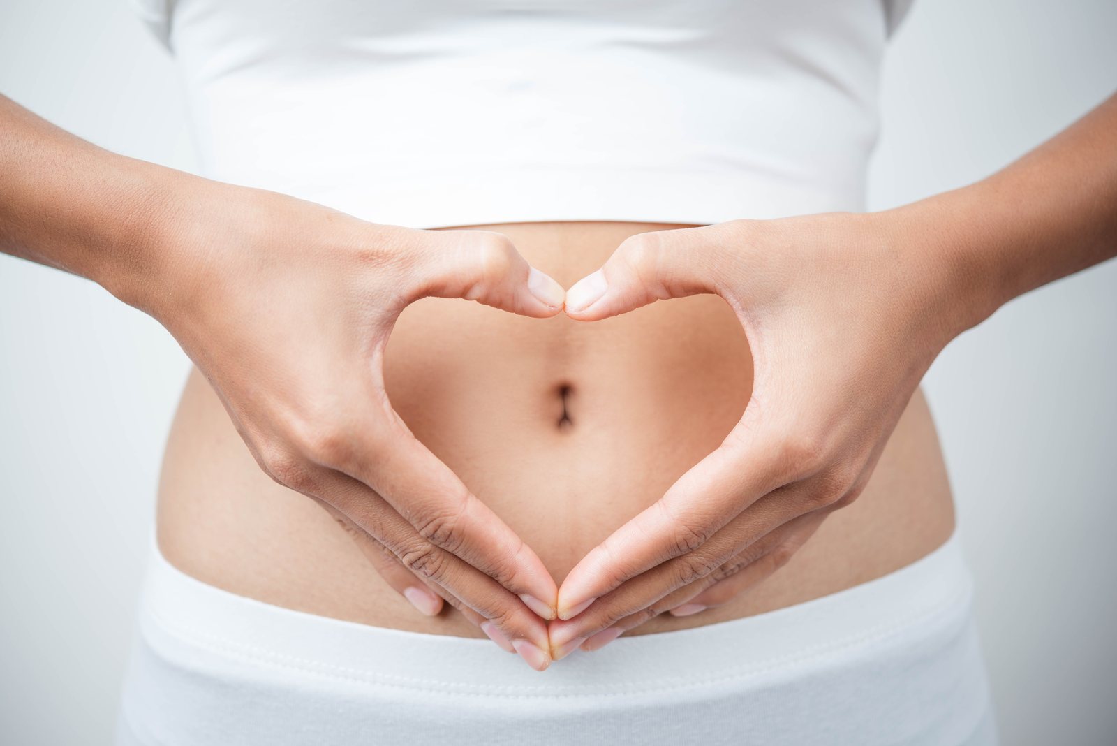 Mani a forma di cuore sull'addome come simbolo di equilibrio e benessere alimentare a Bari